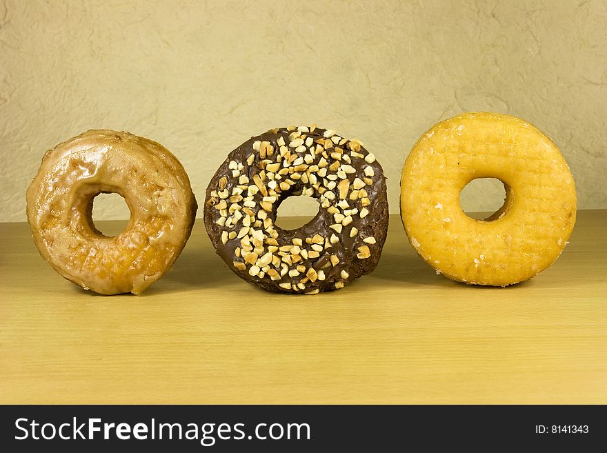 Three fresh donuts on white surface