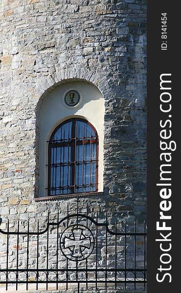 Window with a lattice in a stone wall of church