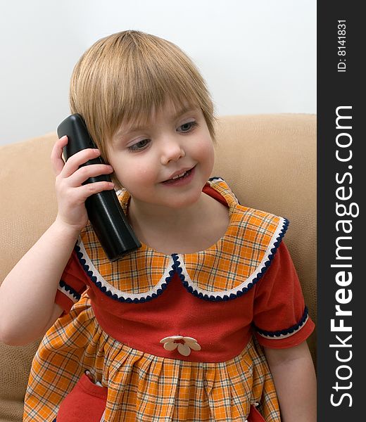 The little girl speaks by phone. The little girl speaks by phone