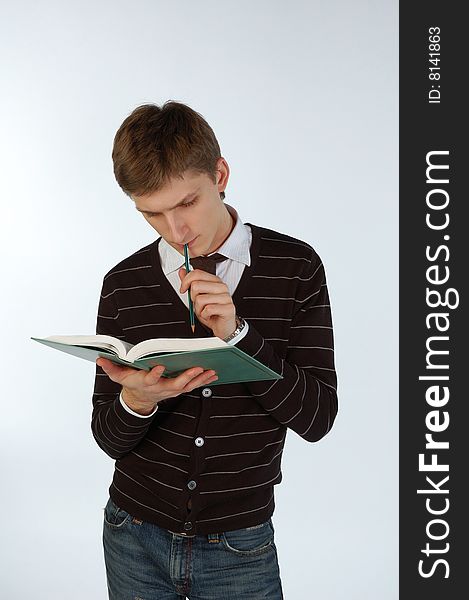 Young man reading a book and making some notes. Young man reading a book and making some notes