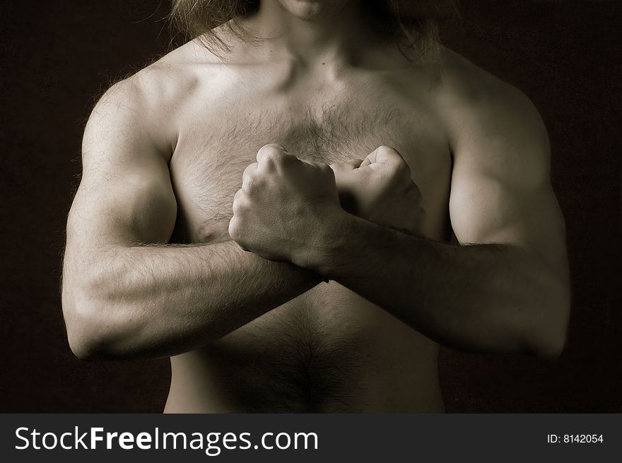 Muscular male torso with crossed arms in a sign of 'X'