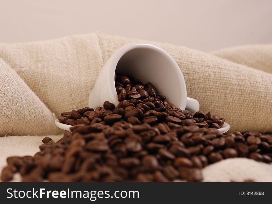 Cup of coffee with coffee benas and hemp fabric