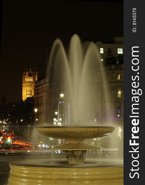 The fountain of trafalgar quare, the house of parliament, a bus and trafic in london by night with a long exposure. The fountain of trafalgar quare, the house of parliament, a bus and trafic in london by night with a long exposure