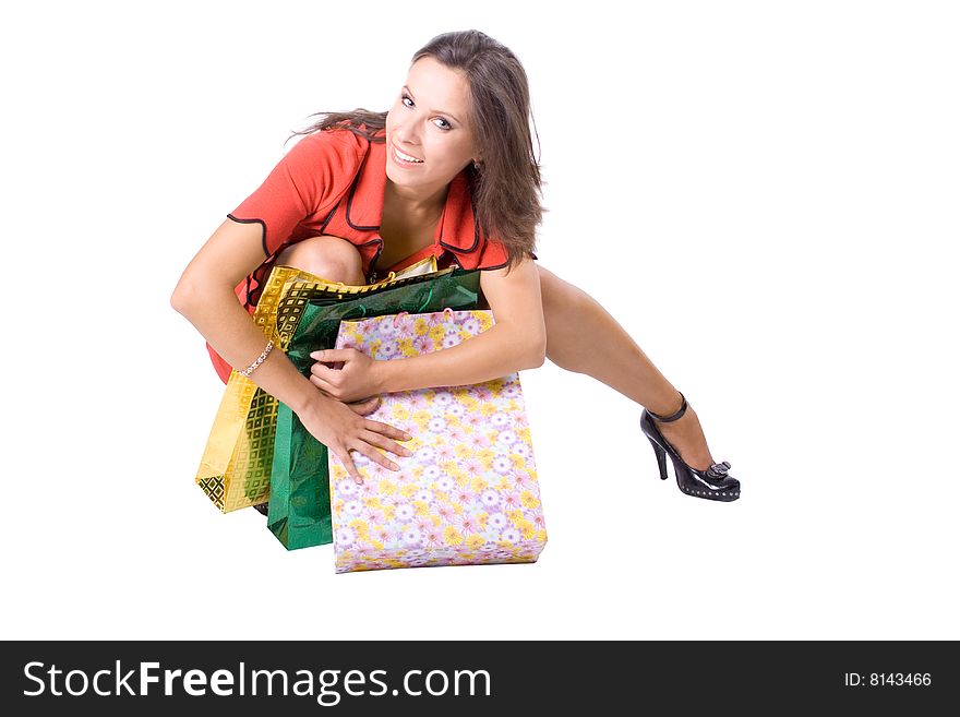 The young beautiful girl with purchases in colour packages during shopping on a white background. The young beautiful girl with purchases in colour packages during shopping on a white background