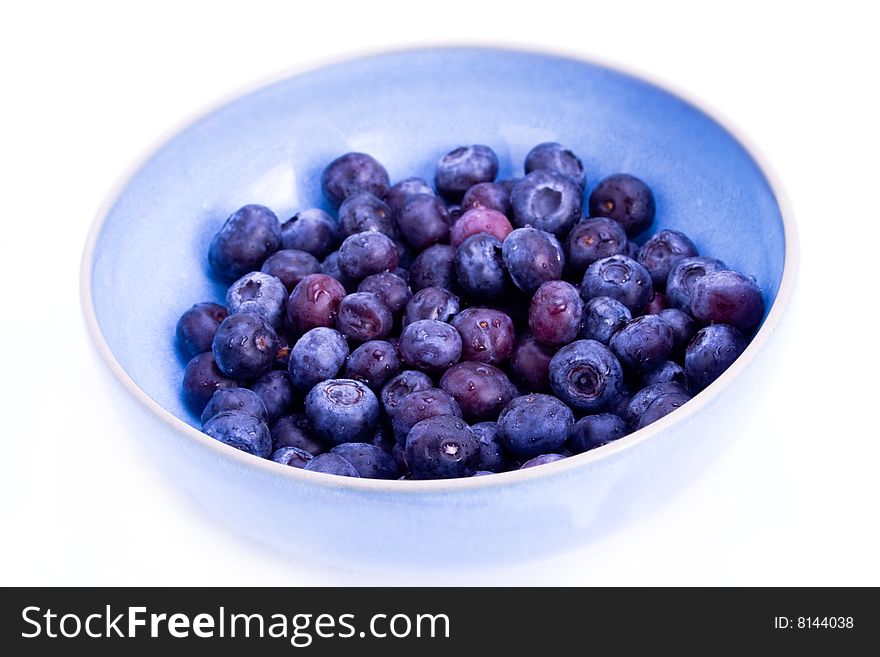 A blue bowl filled with fresh blueberries. A blue bowl filled with fresh blueberries