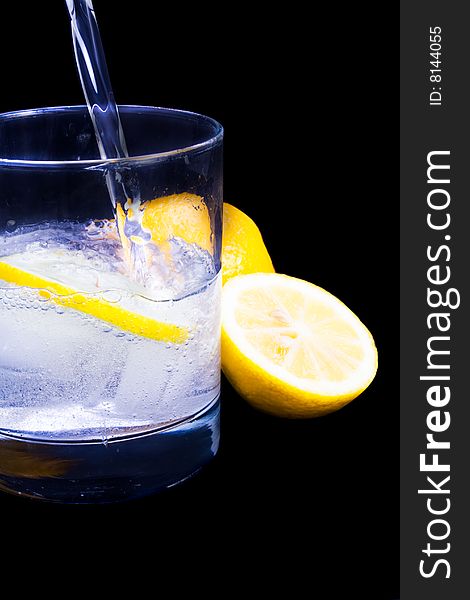 A refreshing drink being poured against black background. A refreshing drink being poured against black background