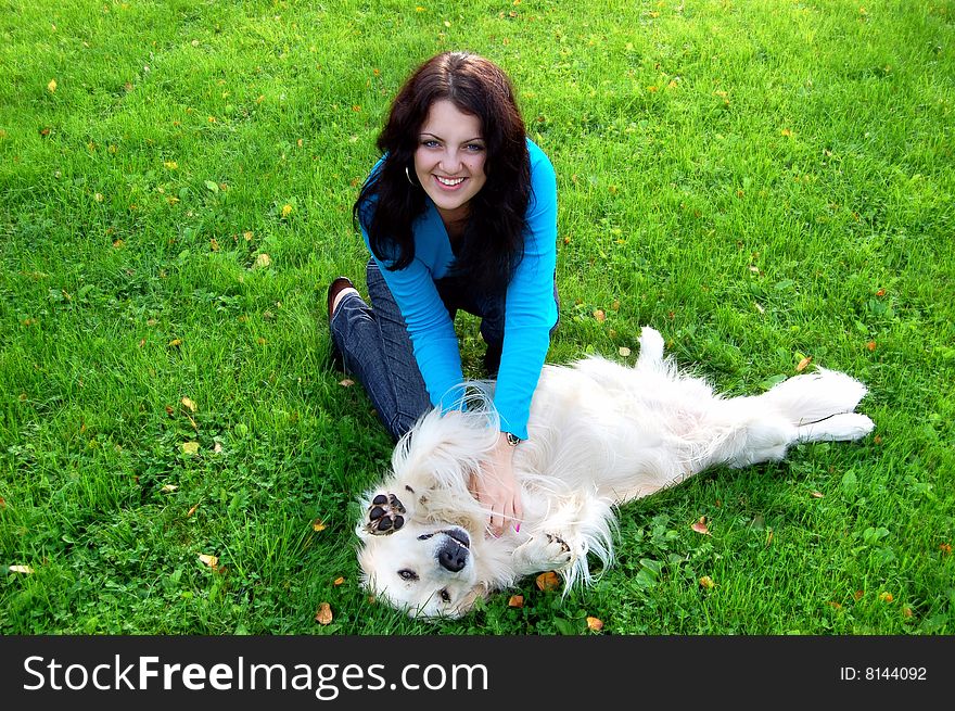 Happy beautiful young brunet girl playing with golden retriever. Happy beautiful young brunet girl playing with golden retriever