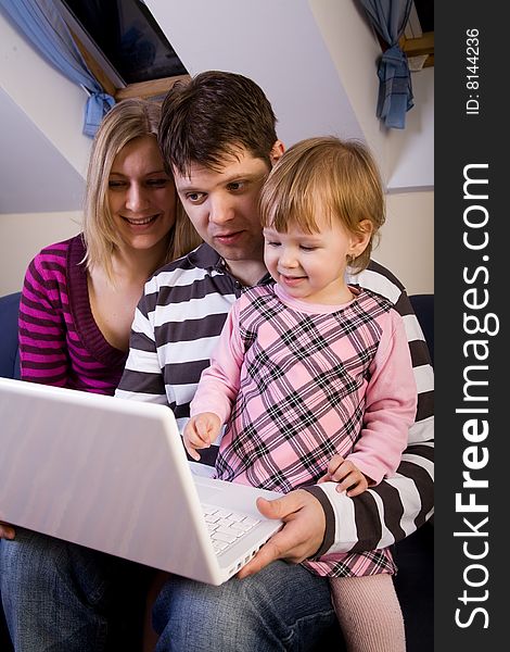 Little Girl With Parents Play With A Laptop