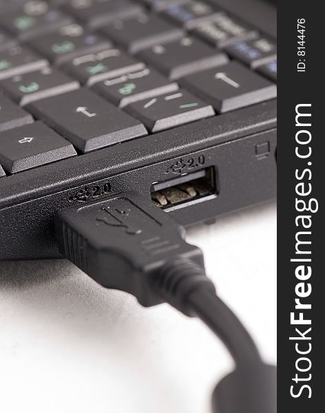 USB cable plugged into a laptop computer. USB cable plugged into a laptop computer