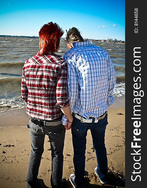 Two young women standing on the beach and holding hands