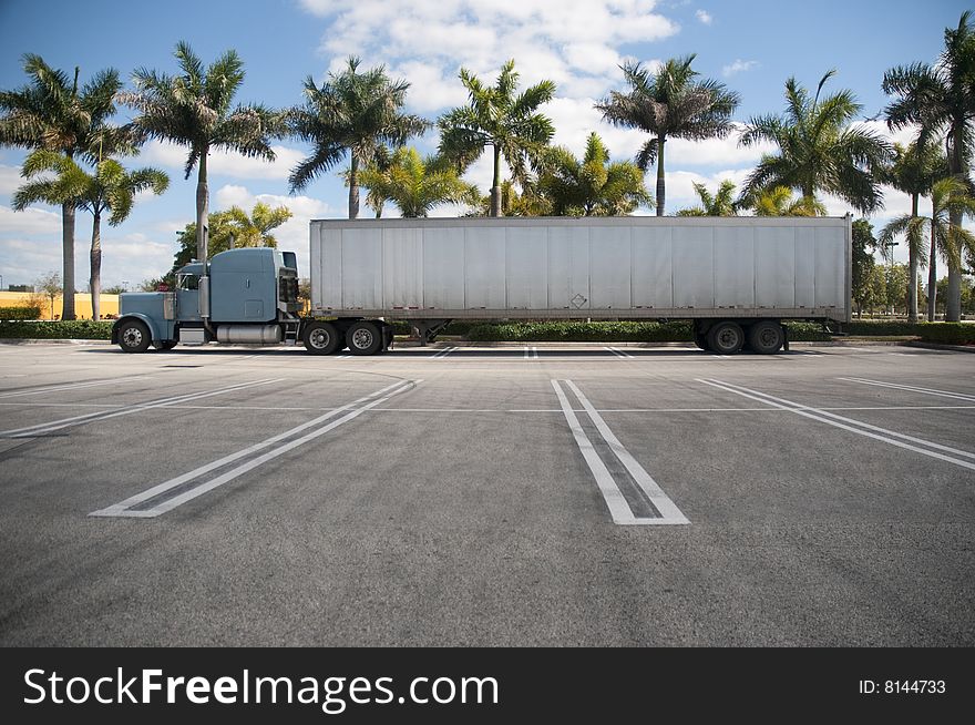Parked Semi with tropical background and an empty parking lot
