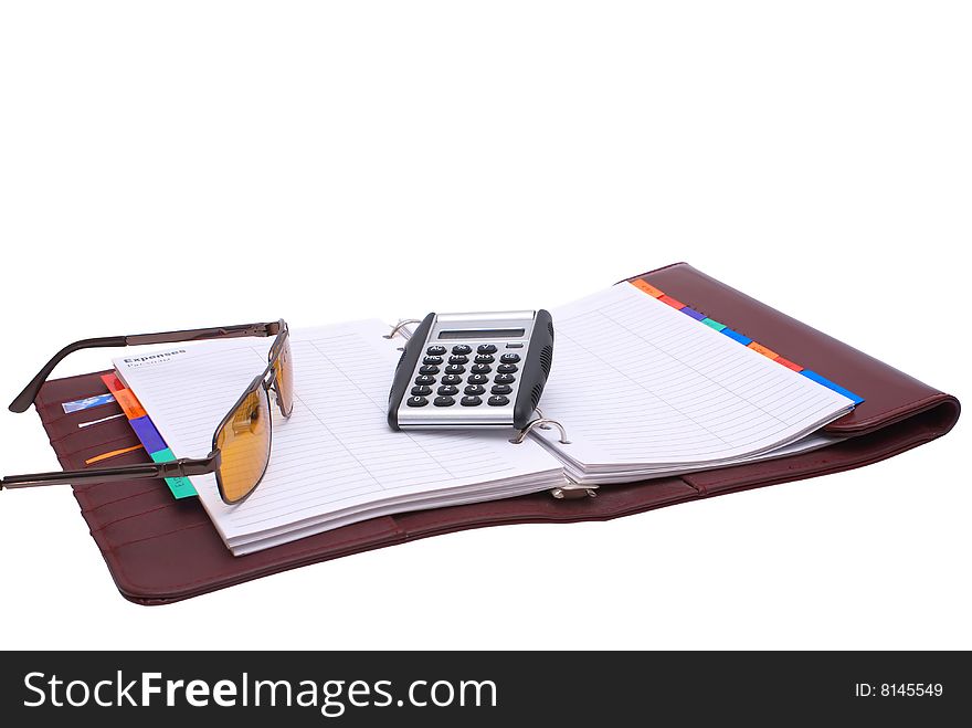 Outdoor notebook book with glasses and a calculator on a white background. Outdoor notebook book with glasses and a calculator on a white background.