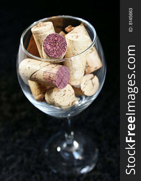 Wine corks displayed in a wine glass on a black backdrop. Wine corks displayed in a wine glass on a black backdrop