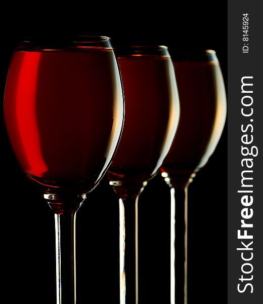 Three small glasses filled with colorful liquor on black background. Three small glasses filled with colorful liquor on black background