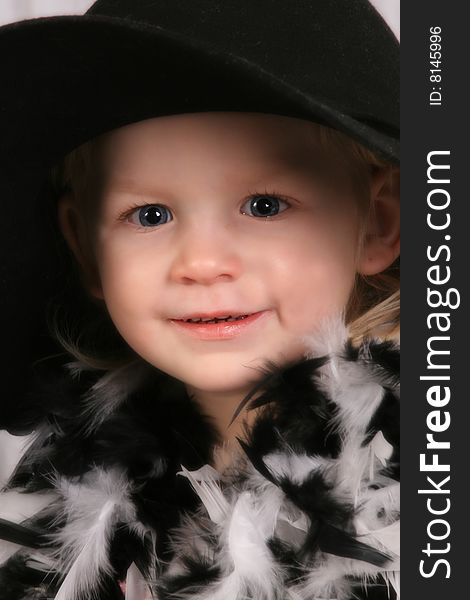 Young girl with black hat and black and white feather boa. Young girl with black hat and black and white feather boa
