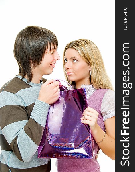 Young couple in incomprehension with gift packet on white. Young couple in incomprehension with gift packet on white