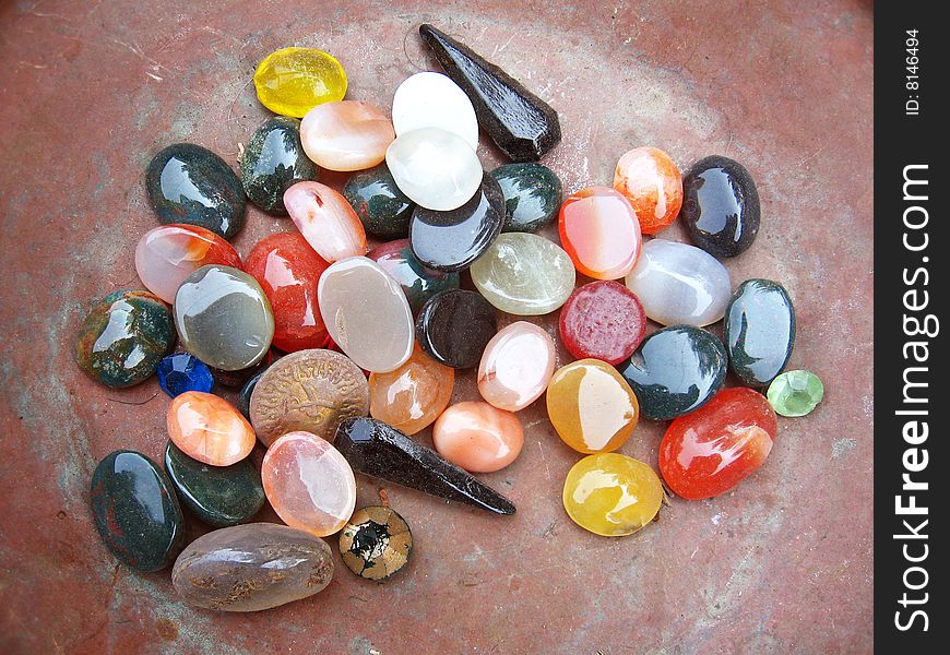 A background of colorful stones of different shape kept in a iron pan. A background of colorful stones of different shape kept in a iron pan