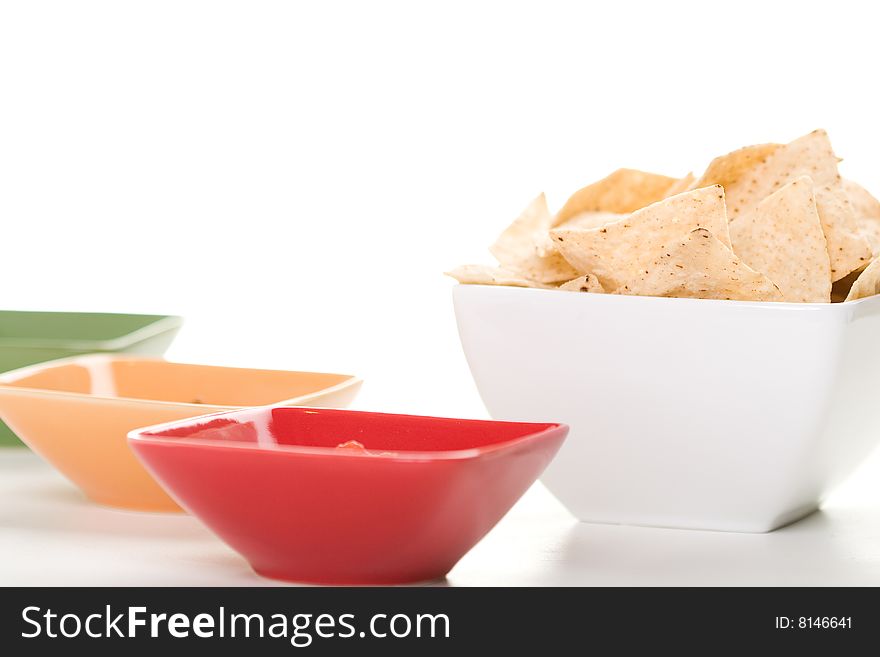 Tortilla chips served with salsa in colorful bowls. Tortilla chips served with salsa in colorful bowls