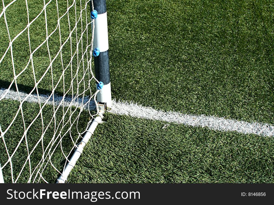 Detail of goal net in green grass - sport symbol