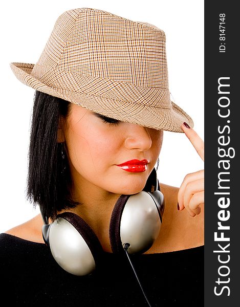 Portrait of young female wearing headphone and hat against white background