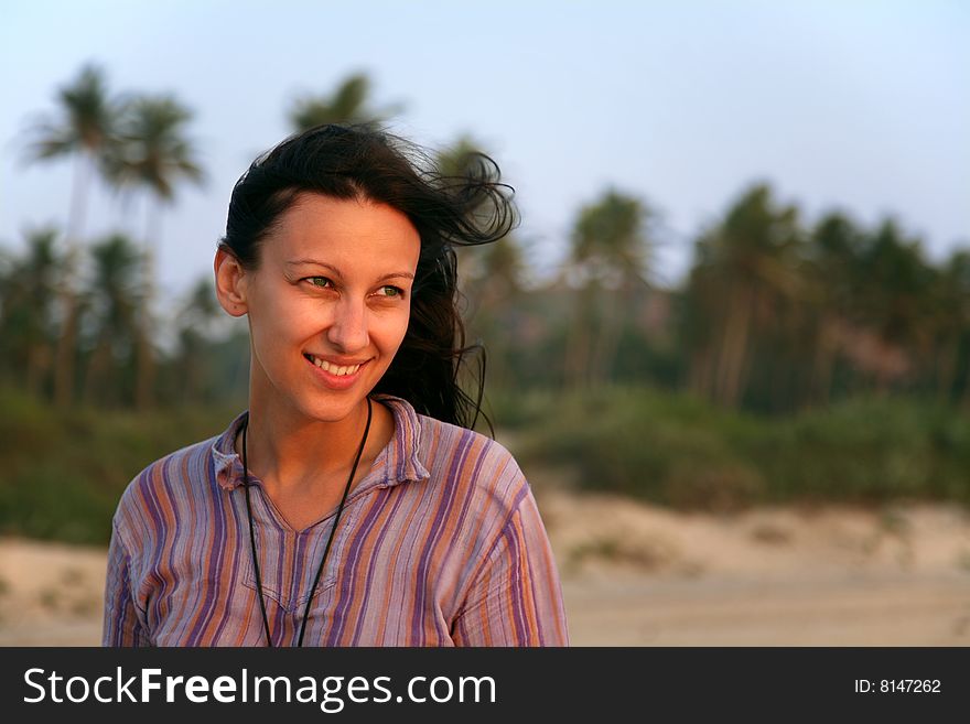 Pretty young woman over green palms on the beach. Pretty young woman over green palms on the beach