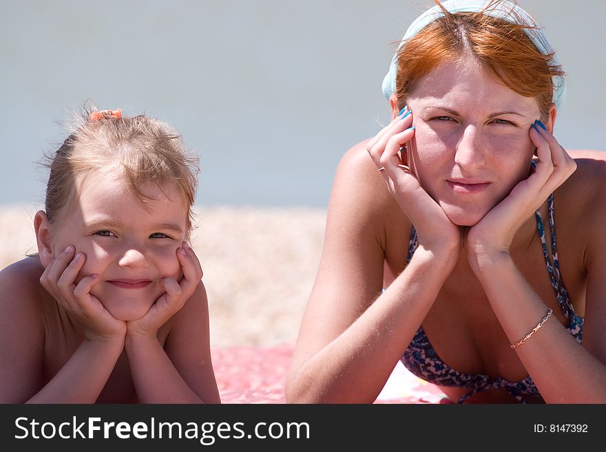 Mother and daughter posing happily on blue fuzzy background.