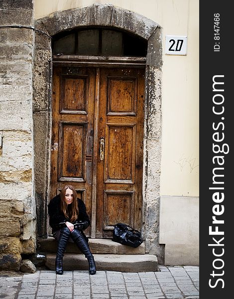 Stock photo: an image of a woman sitting at the door. Stock photo: an image of a woman sitting at the door