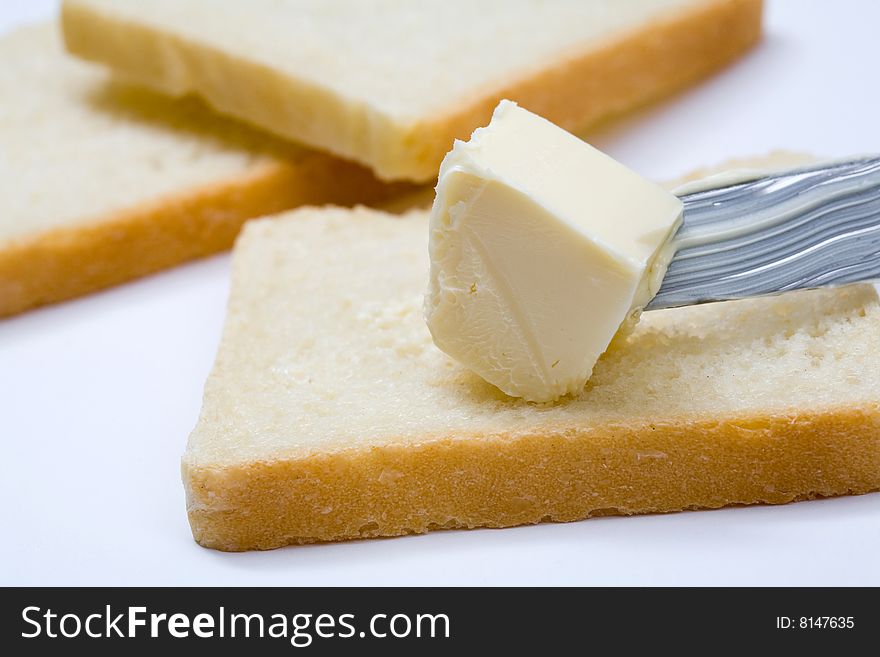 Stock photo: an image of fresh butter on a knife and slices of bread. Stock photo: an image of fresh butter on a knife and slices of bread