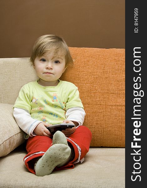 Baby girl with remote control on  sofa