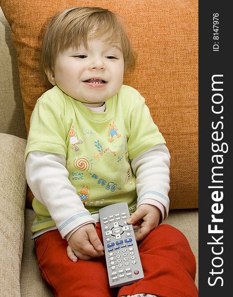 Baby girl with remote control on  sofa