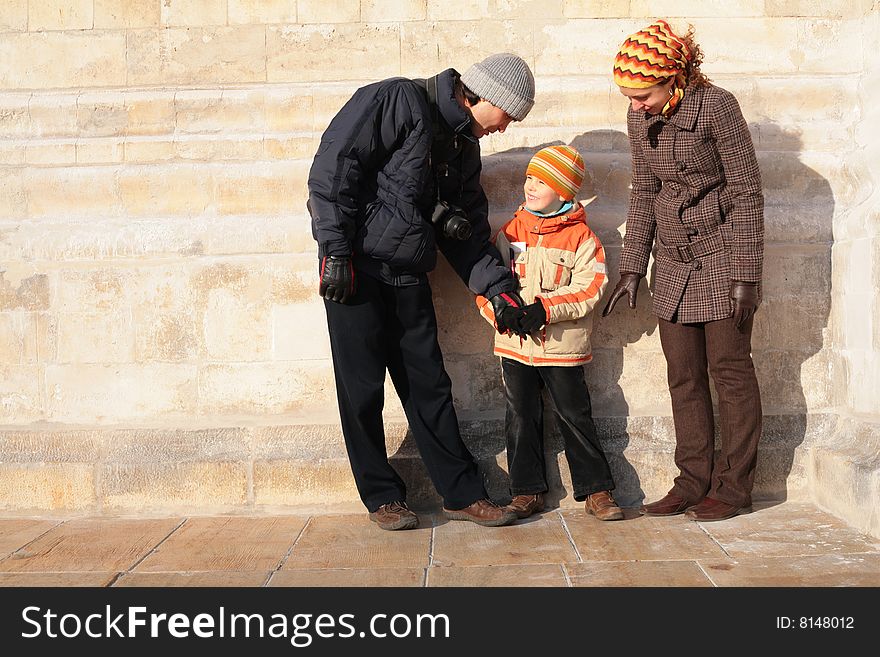 Family of three person against a stone wall. Family of three person against a stone wall