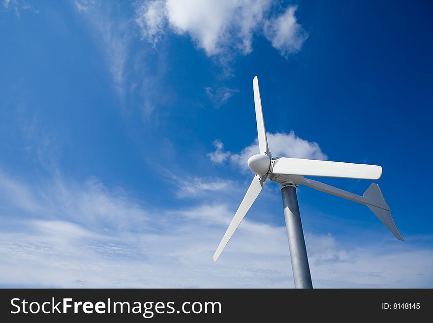 A wind turbine in a beautiful blue and cloud sky. A wind turbine in a beautiful blue and cloud sky