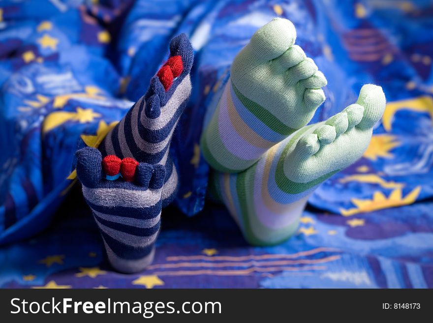 Stock photo: an image of two pairs of feet in striped socks. Stock photo: an image of two pairs of feet in striped socks