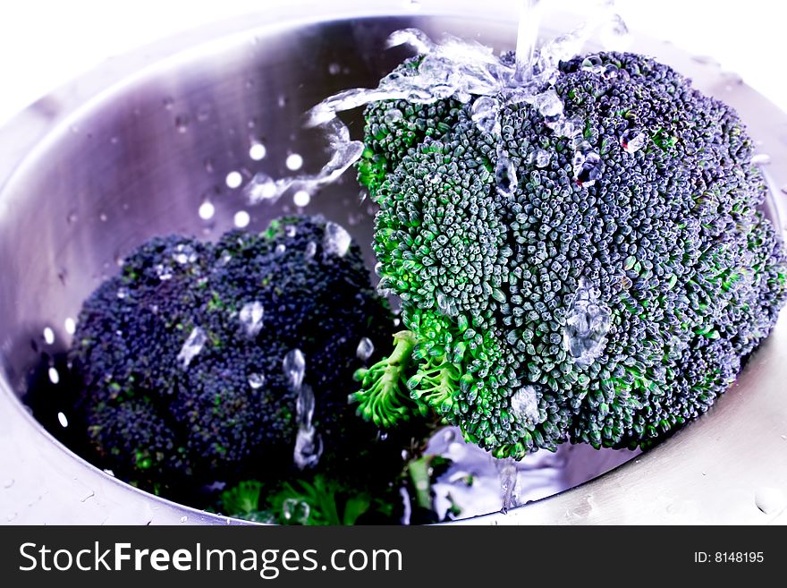 Fresh Broccoli splashed with water in colander. Fresh Broccoli splashed with water in colander