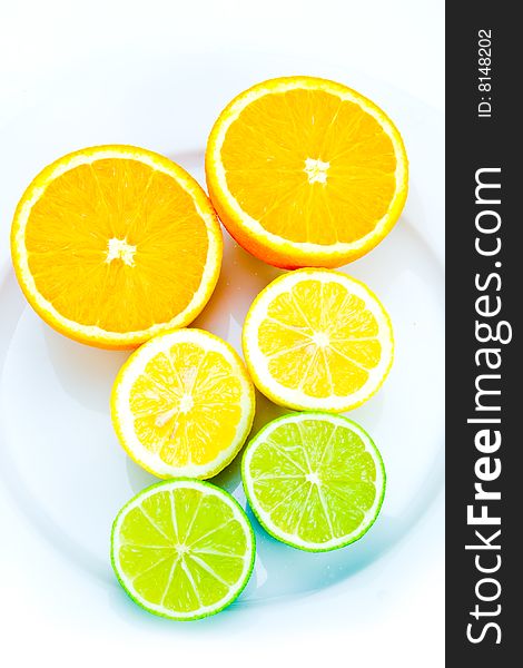 Arrangement of citrus fruits on plate on white. Arrangement of citrus fruits on plate on white
