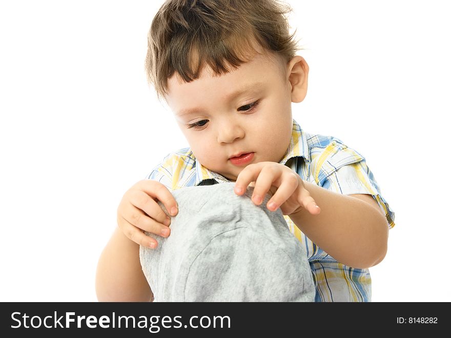 One year old boy putting on a hat