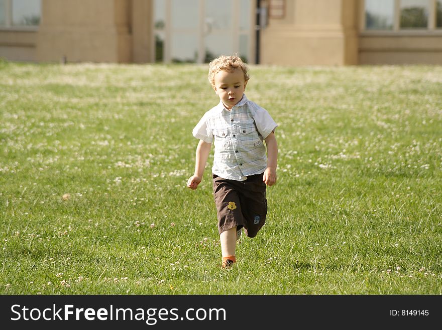 Toddler runing on the grass in urban park. Toddler runing on the grass in urban park