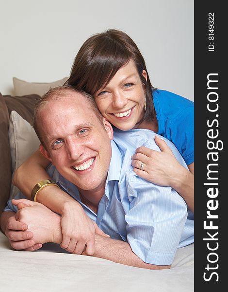 Beautiful young couple on a couch in their new appartment. Beautiful young couple on a couch in their new appartment.