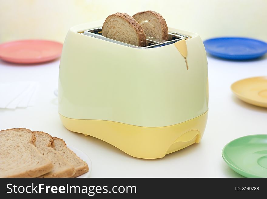 A table setting with breakfast food and toaster. A table setting with breakfast food and toaster