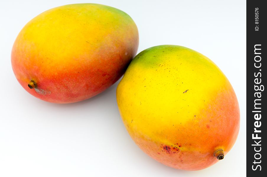 Still life of two mangoes on white background