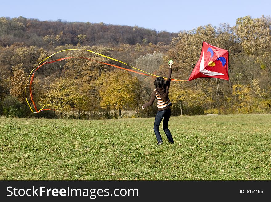 Fly a kite, teenager in fall weather in nature