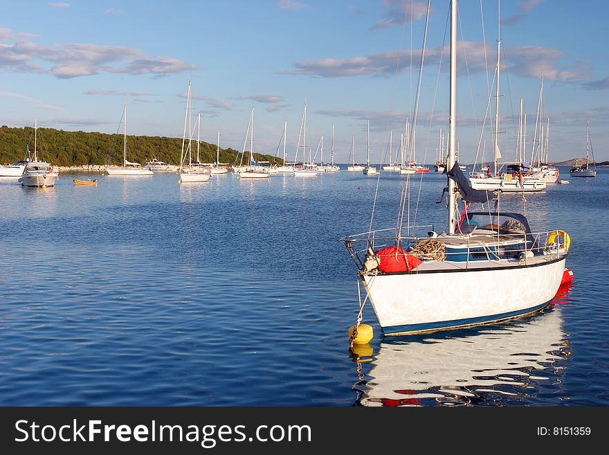 Late afternoon sailing boats mooring in a bay of Croatian Islands. Late afternoon sailing boats mooring in a bay of Croatian Islands