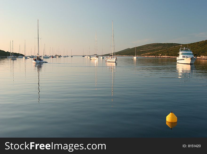 Late afternoon sailing boats mooring in a bay of Croatian Islands. Late afternoon sailing boats mooring in a bay of Croatian Islands