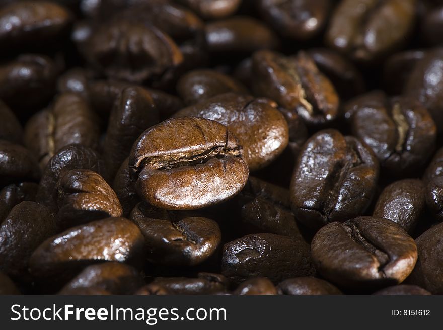 Fresh brown coffee beans background. Full frame. Shallow depth of field. Focus on 1 bean.