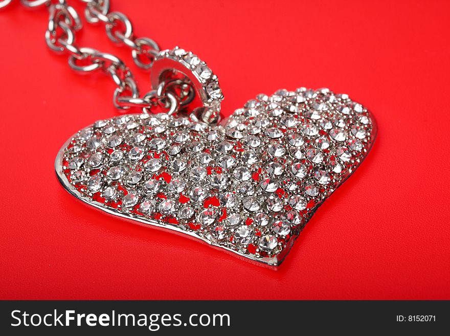 A silver heart on a red background. A silver heart on a red background
