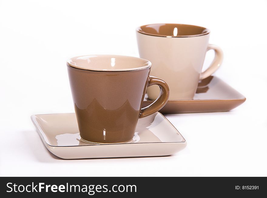 Two brown and beige cups of tea with saucers. Two brown and beige cups of tea with saucers