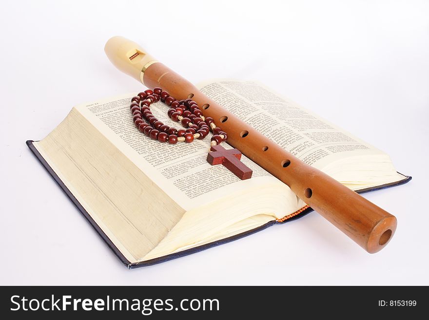 Flute with bible and rosary in white background. Flute with bible and rosary in white background