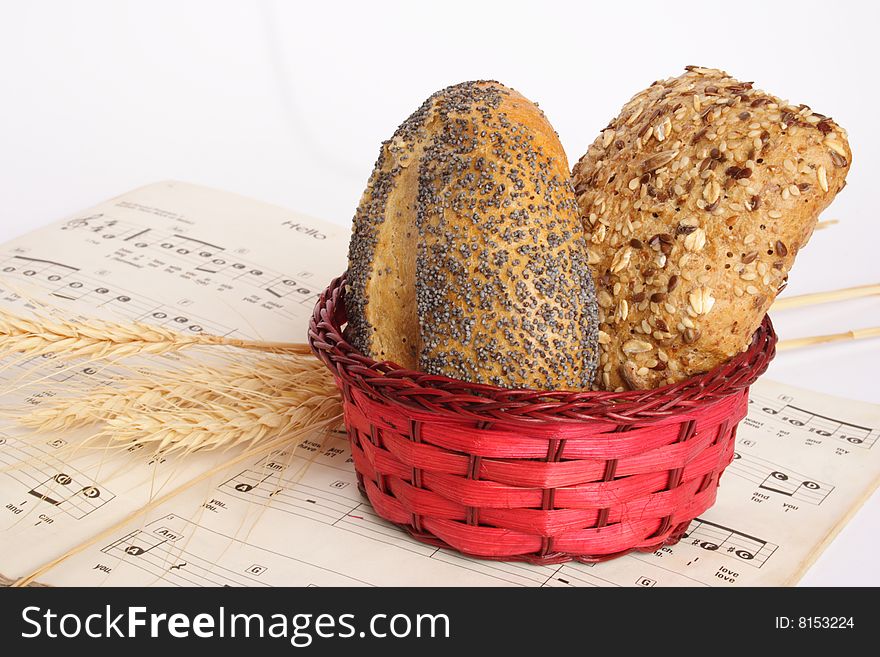 Small red basket with bread and music book. Small red basket with bread and music book