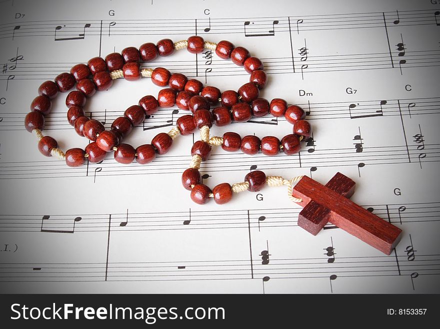 Close up of rosary over a music sheet