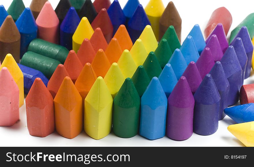 Rainbow stacked wax crayons on colored background